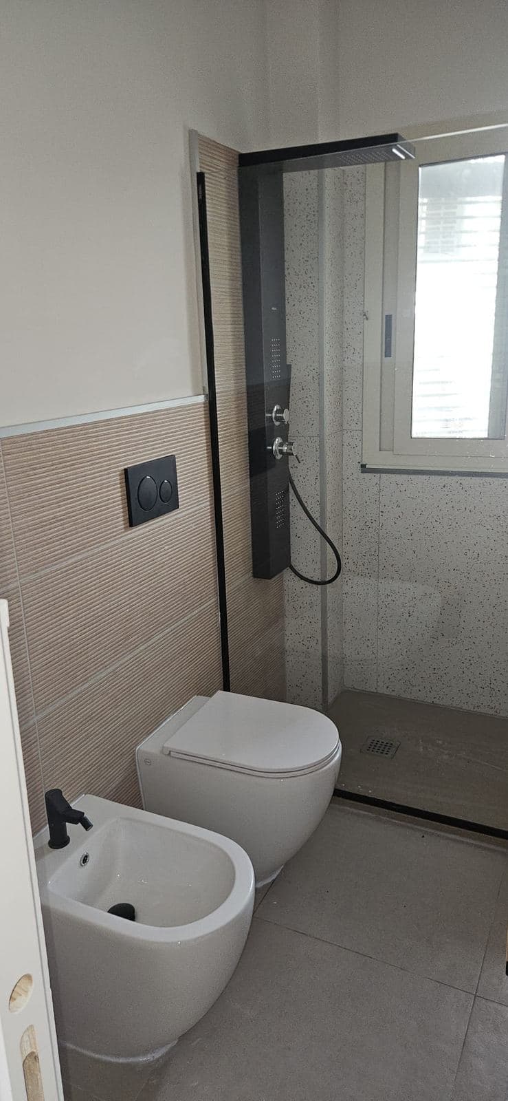 Bagno con doccia e sanitari sospesi